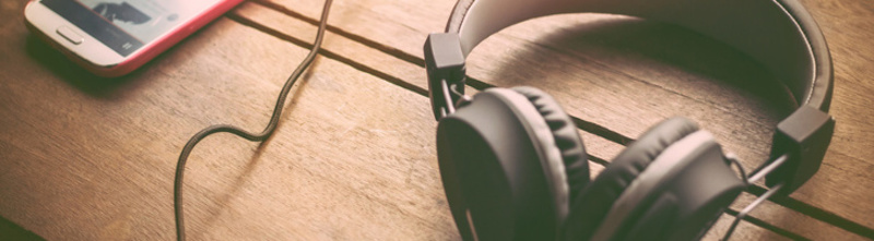 Headphones, and mobile phones placed on the wood in sunset background Headphones, and mobile phones placed on the wood in sunset background