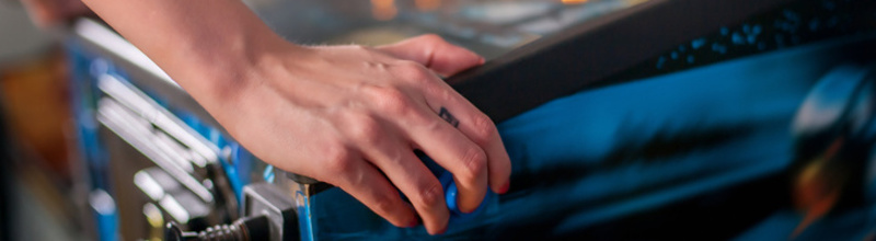 Hand of female pressing button and playing pinball machine Hand of female pressing button and playing pinball machine